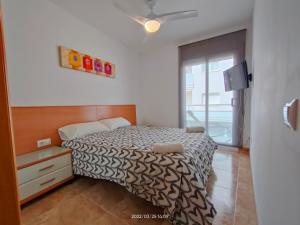 a small bedroom with a bed and a window at LG Calafell Beach in Calafell