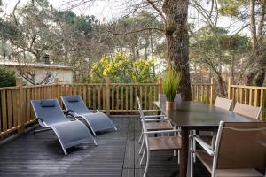 a patio with a table and chairs on a deck at LA PETITE MAISON DU LAC in Biscarrosse +6 photos