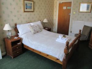 1 dormitorio con 1 cama grande con marco de madera en Ashwood Grange, en Torquay