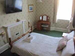 a bedroom with a bed with a television on the wall at Ashwood Grange in Torquay