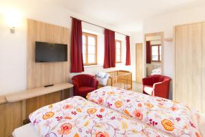 a hotel room with a bed and two red chairs at Gasthaus Paulus in Neustadt an der Donau