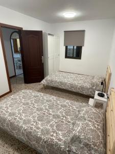 1 Schlafzimmer mit 2 Betten und einer Tür in der Unterkunft Casa Candelaria in La Laguna + 30 Fotos