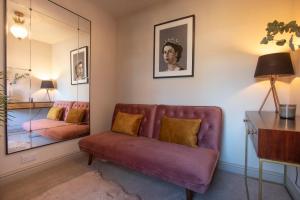 a living room with a couch and a mirror at Beautiful Luxe Victorian Townhouse - 5 mins walk from Warwick Castle & town in Warwick