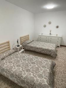 a bedroom with two beds and a dresser at Casa Candelaria in La Laguna