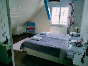 a bedroom with two beds and a blue chair at Apartamenty TRZY PTAKI in Wisła