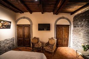 a bedroom with two chairs and a tv on the wall at Il giardino nel borgo in Viterbo