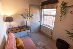 a living room with a pink couch and a window at Luxury Townhouse - close to castle & town - perfect stylish stay, sunny private courtyard, dog friendly in Warwick