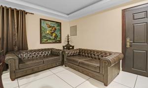 un sofá de cuero en una habitación con puerta en Treebo Trend Anchor Inn, en Kochi