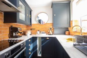 a kitchen with blue cabinets and a sink at Beautiful Boutique Townhouse - 5 mins walk from Warwick Castle & town in Warwick