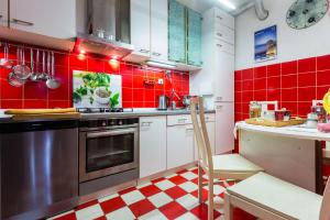 cocina roja y blanca con fogones y encimera en Bristol lux 3BR apartment with view, en Zadar