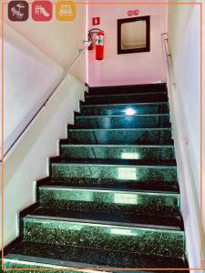 a staircase with green steps and a fire extinguisher at Anexo - Hospedagens Imigrantes in São Pedro