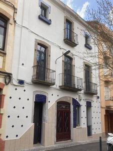 CAN LLAVI - TARTANA في كانيه دي مار: مبنى أبيض شبابيكه وشرفات على شارع