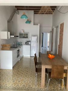 a kitchen with a table and chairs in a kitchen at CAN LLAVI - TARTANA in Canet de Mar