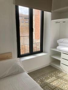 Schlafzimmer mit einem Bett und einem Fenster mit Aussicht in der Unterkunft CAN LLAVI - TARTANA in Canet de Mar