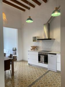 a kitchen with white cabinets and a stove top oven at CAN LLAVI - TARTANA in Canet de Mar