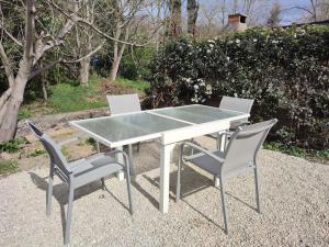 mesa con 2 sillas y mesa con encimera de cristal en Gîte chaleureux "Le Figuier" - Val-du-Faby, en Fa