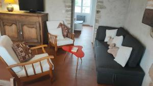 Le Champ des Fougères في Vicq-Exemplet: غرفة معيشة مع كنبتين وكرسي احمر