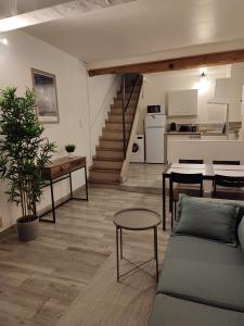 un salon avec un canapé et une table et une cuisine dans l'établissement Gîte chaleureux "Le Figuier" - Val-du-Faby, à Fa