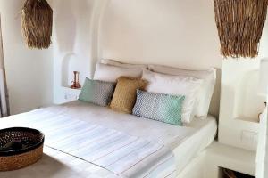ein weißes Bett mit Kissen auf dem Zimmer in der Unterkunft Mor Panjurlu Bohem Tasarım Ev - Kazdağları & Deniz in Ayvacık