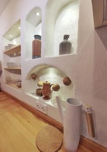 uma cozinha com uma prateleira com vasos em Yerden Isıtma ve Şömineli Salvia - Sakin ve Bohem em Ayvacık