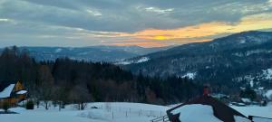 a view of a snow covered mountain with a sunset at Apartamenty TRZY PTAKI in Wisła