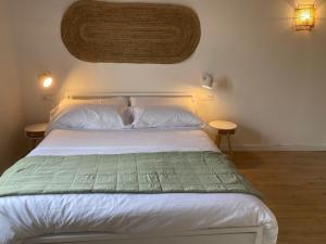een slaapkamer met een wit bed en 2 tafels bij Can Llavi in Canet de Mar