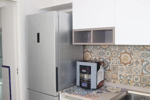 una cucina con frigorifero e macchinetta del caffè su un bancone di La Lucciola ad Amalfi Altre 18 foto
