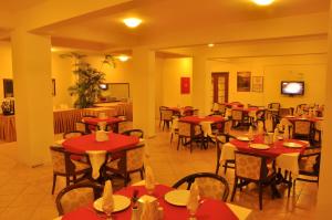 un restaurante con mesas y sillas con manteles rojos en Kaunos Hotel, en Koycegiz