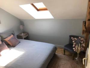 a bedroom with a bed and a skylight at Logement à Brive, près du centre-ville et de la gare - Climatisation, fibre internet et stationnement gratuit in Brive-la-Gaillarde