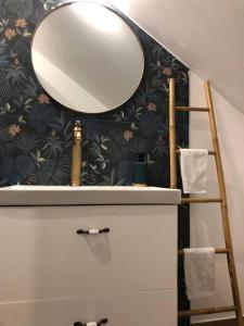 a mirror on top of a dresser in a bathroom at Paisible logement à Brive, près du centre-ville et de la gare - Netflix, Fibre internet et Stationnement gratuit in Brive-la-Gaillarde