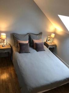 a bedroom with a blue bed with two night stands at Logement à Brive, près du centre-ville et de la gare - Climatisation, fibre internet et stationnement gratuit in Brive-la-Gaillarde