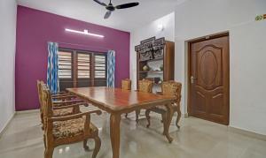 a dining room with a wooden table and chairs at Treebo Backpackers Inn in Cochin