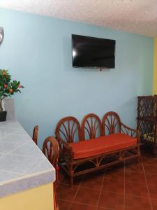 ein Wohnzimmer mit Tisch und Stühlen und einem Fernseher in der Unterkunft Villas La Bella Margarita in Brisas de Zicatela