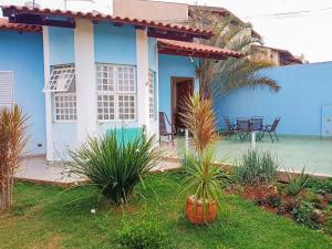 Casa azul y blanca con mesa y sillas en Casa Azul Antares 3 Quartos - Pet Friendly, en Londrina