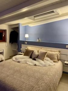 una camera con un grande letto con una parete blu di Il cielo in una stanza a Itri