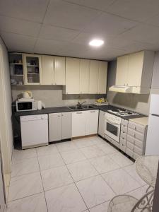 a kitchen with white cabinets and white appliances at Hostel Hakuna Matata in Dubrovnik