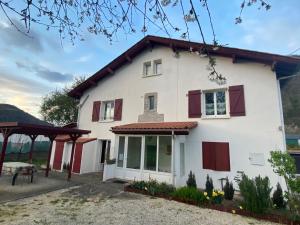 Casa blanca con ventanas rojas y patio en MAISON AMORAINA, en Ascarat