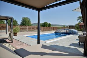 a patio with a swimming pool and a fence at Bocor Fogadó in Kisharsány