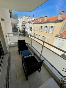 - un balcon avec deux chaises et une table dans l'établissement Apartment Montaigne, à Cannes