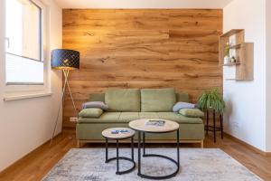 a living room with a green couch and two tables at Ferienwohnung Kerstin in Bad Mitterndorf