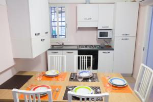a kitchen with a table and chairs and a kitchen with white cabinets at Venice Rialto Bridge Apartment in Venice
