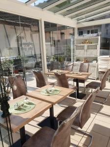 ein Restaurant mit Holztischen und -stühlen auf einer Terrasse in der Unterkunft Gästehaus Ströter in Bacharach