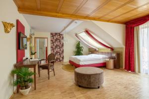 Hotel l'adresse garni في Heusweiler: غرفة نوم بسرير ومكتب وطاولة