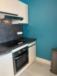- une cuisine équipée d'un four avec plaques de cuisson en noir et blanc dans l'établissement Appt traversant vu Mer et Dunes avec Garage, à Le Touquet-Paris-Plage