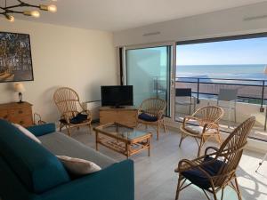 un salon avec un canapé, des chaises et une télévision dans l'établissement Appt traversant vu Mer et Dunes avec Garage, à Le Touquet-Paris-Plage 27 autres photos