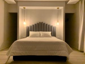 1 dormitorio con 1 cama grande y 2 luces en Penthouse - Vista Hermosa Apartments, en Filandia