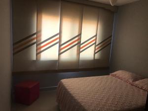 - une chambre avec un lit et un mur avec des drapeaux dans l'établissement Apartamento com vista para o mar, à Arraial do Cabo
