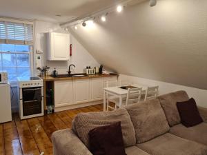 a living room with a couch and a kitchen at The Loft Apartment in Weymouth