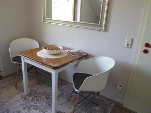 a table with two chairs and a bowl on it at Landhaus Sonneninsel - Appartement in Minheim