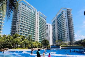 a group of people in the water at a resort at AZURE C1 with balcony wifi MULTIPLE UNITS near airport in Manila